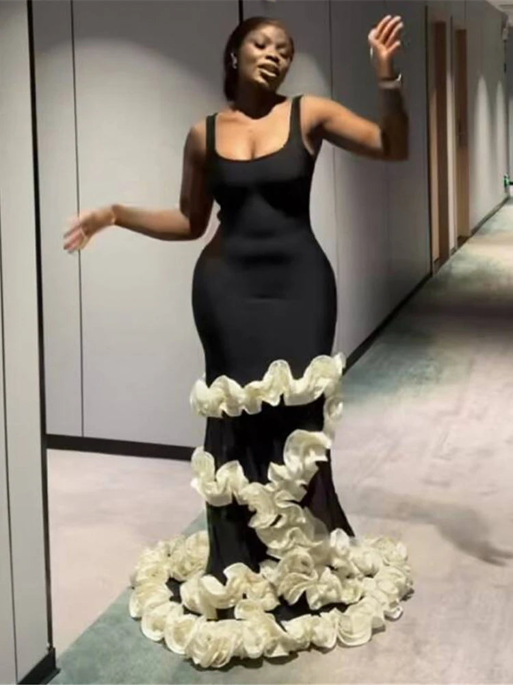 Woman in a black dress with a floral skirt in an indoor setting