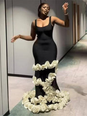 Woman in a black dress with a floral skirt in an indoor setting