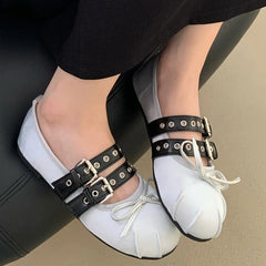 White silk ballet flats with double buckle straps and butterfly knot on a foot