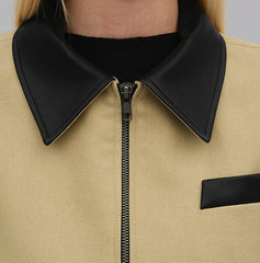 Close-up of a beige jacket with black collar and zipper