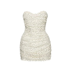 White strapless dress with black polka dot pattern on a white background