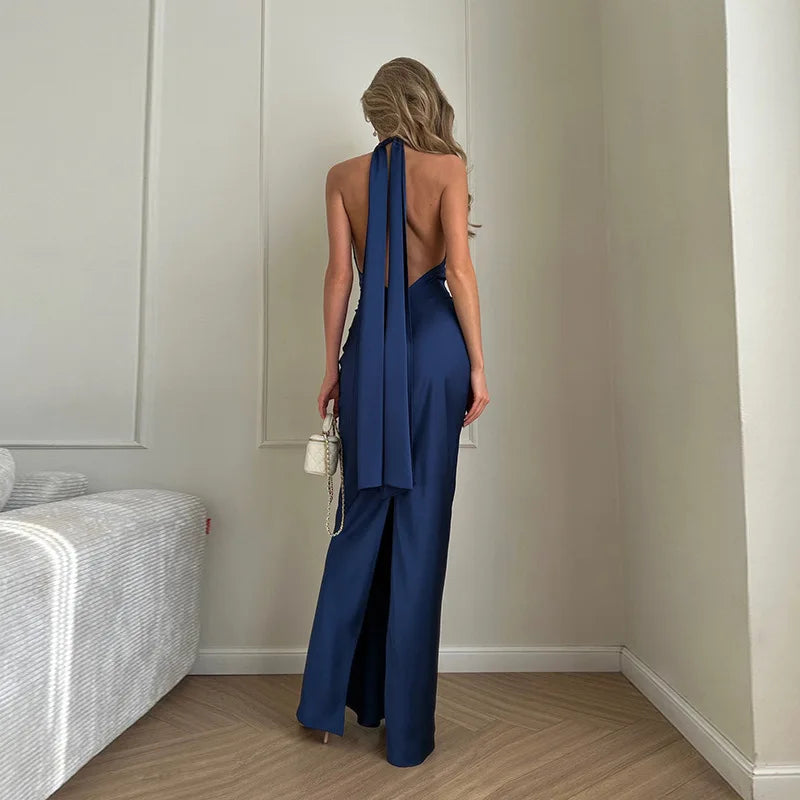 Woman in a blue jumpsuit standing in a room with neutral decor.