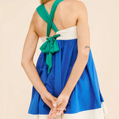 Woman wearing a blue and green dress with a beige background