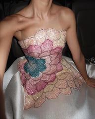 Strapless dress with floral embellishments and sequins on a dark background