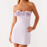 White strapless dress with floral embellishments on a white background