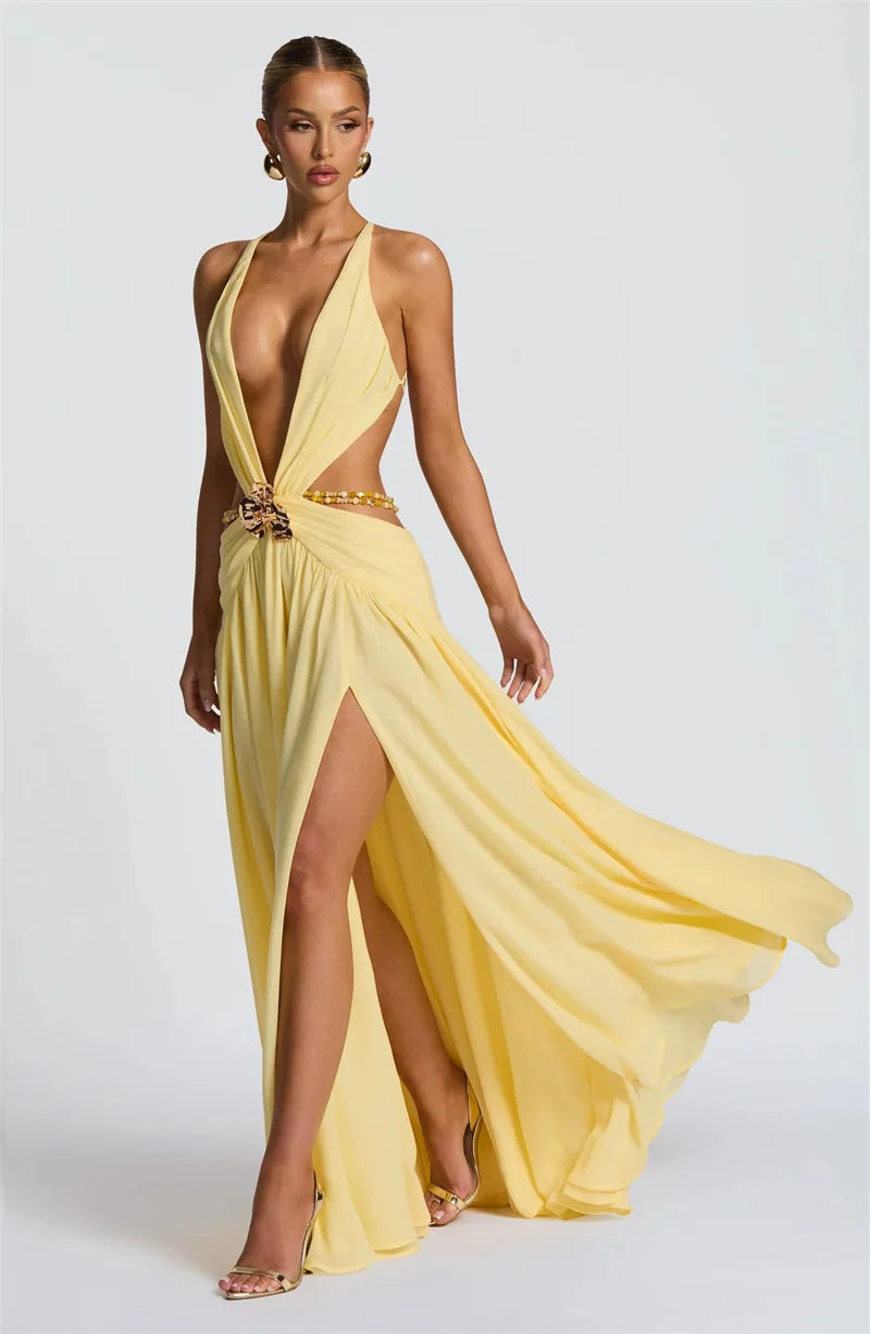 Woman wearing a yellow evening gown with a slit on a white background