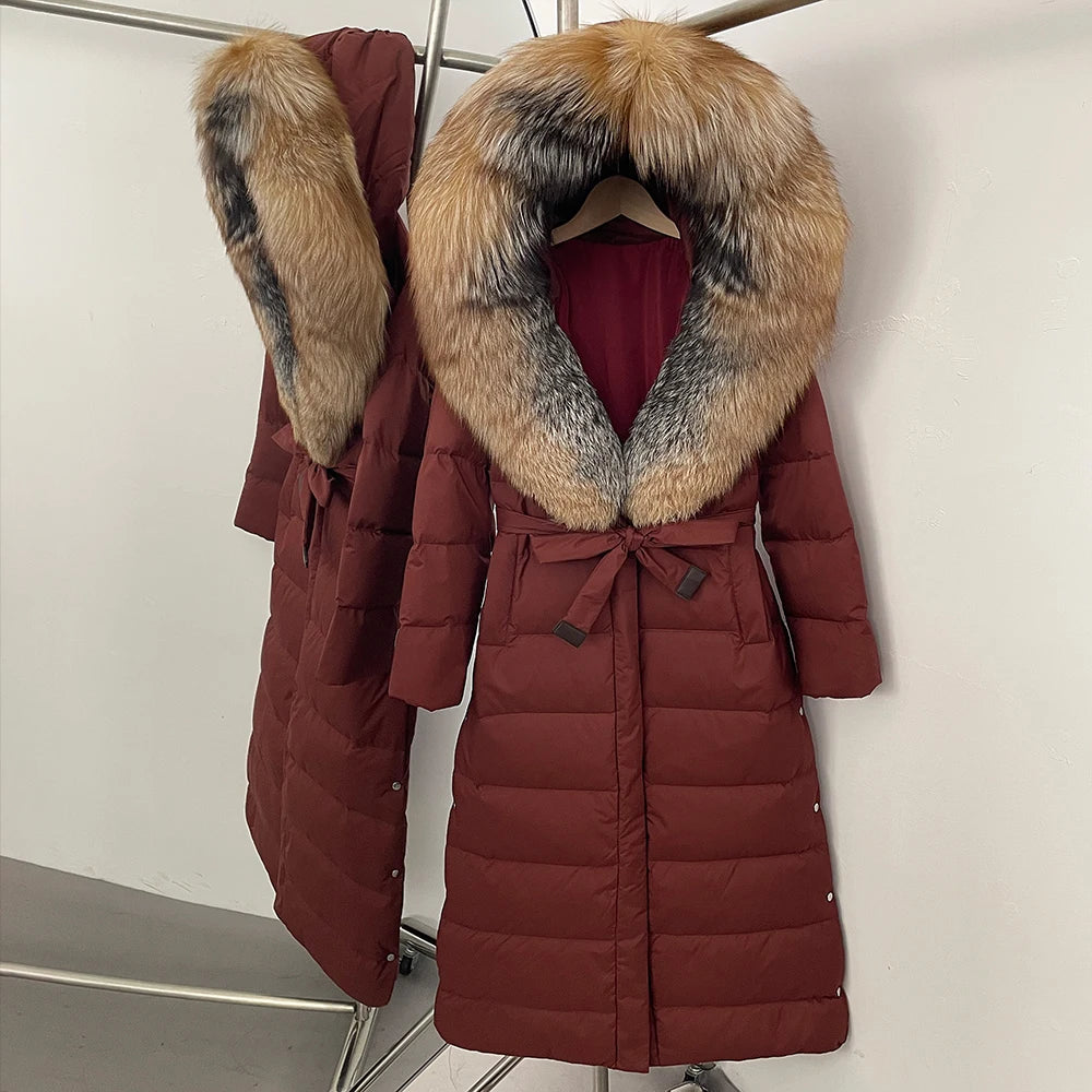 Red puffer coat with fur hood on a hanger against a white background