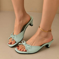 Light blue high-heeled shoes worn by a person on a beige background