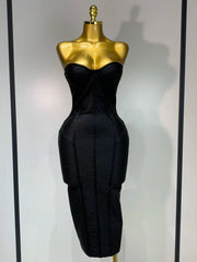 Black strapless dress on a gold mannequin against a white background