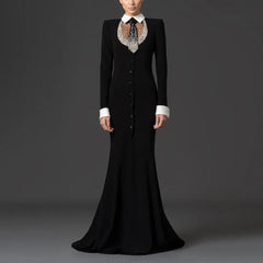 Model wearing a black floor-length dress with a white collar and beaded embellishment.