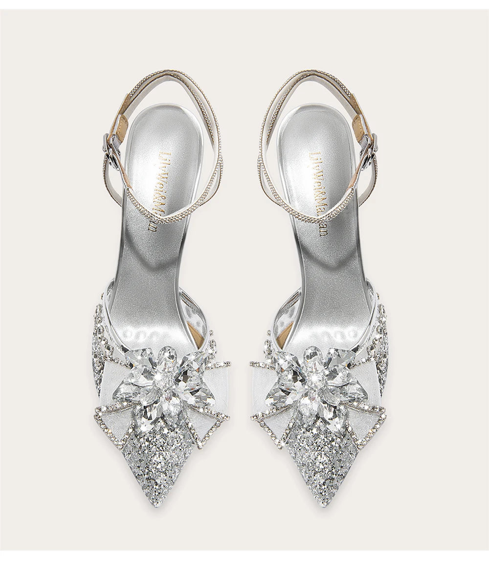 Silver high-heeled shoes with crystal embellishments on a white background