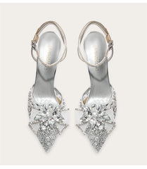 Silver high-heeled shoes with crystal embellishments on a white background
