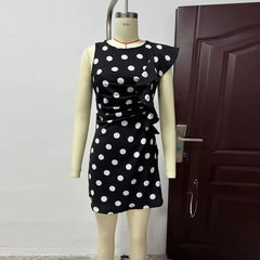 Black dress with white polka dots on a mannequin against a door background