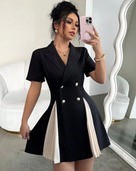 Woman taking a mirror selfie wearing a black and white dress.