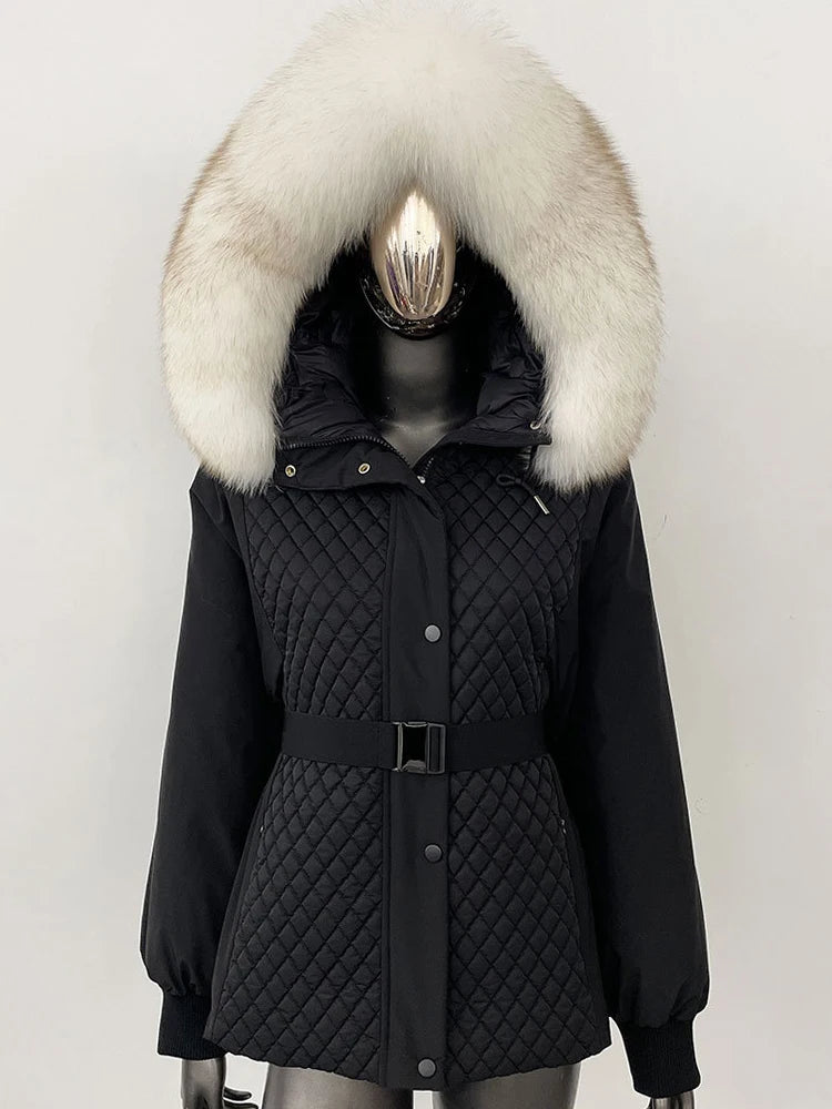 Black quilted parka with a large fur hood on a mannequin against a white background