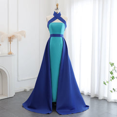 Blue and green evening gown on a mannequin against a white curtain background