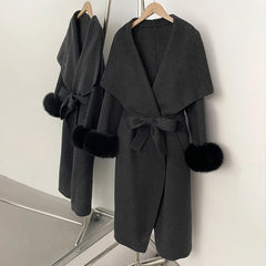 Dark grey wool blend coat with black fur trim and a belted waist.