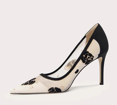 Black and white high-heeled shoe with floral design on a light gray background