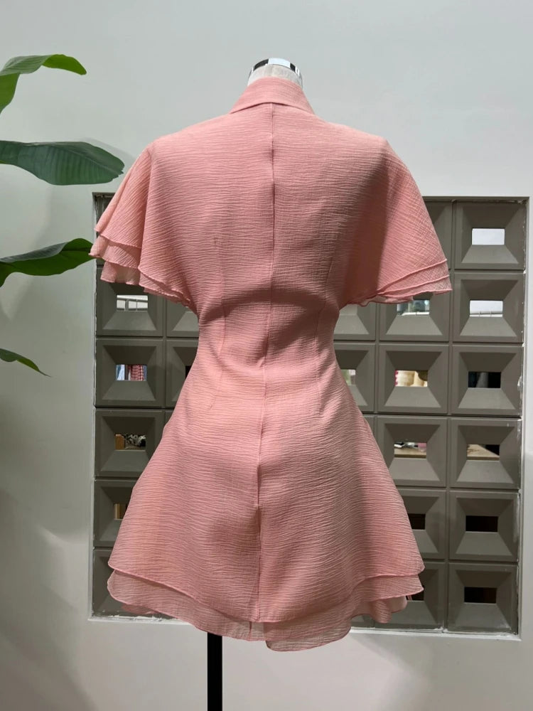 Pink dress on a mannequin against a geometric wall design
