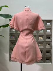 Pink dress on a mannequin against a geometric wall design
