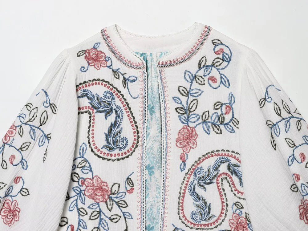 Close-up of the embroidery detail on the front of the white blouse.