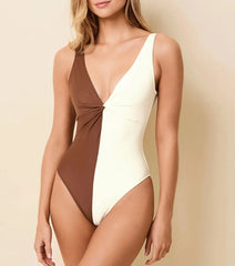 Close-up of a woman wearing a brown and white two-tone one-piece swimsuit with a plunging neckline.