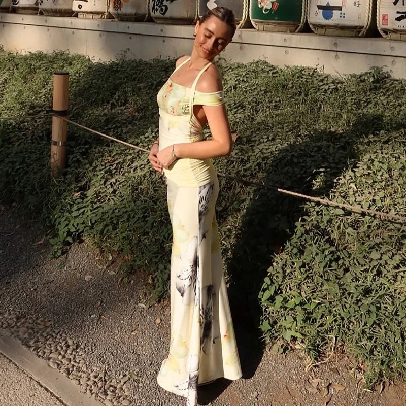 Woman in a long, light-colored dress standing in a field with greenery and traditional Japanese elements.