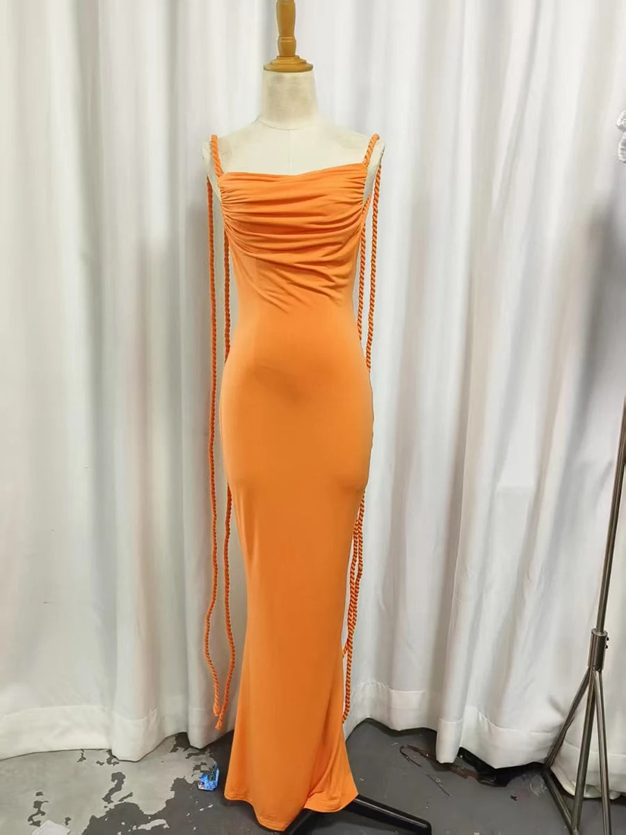 Orange evening gown on a mannequin against a white curtain background
