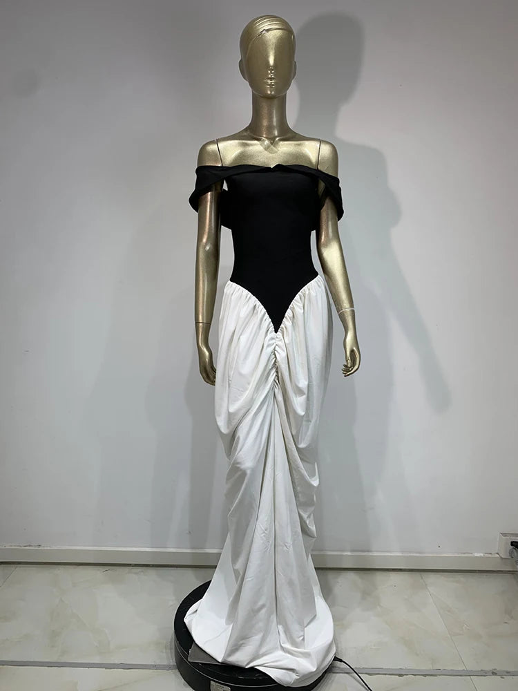 Mannequin wearing a black top and white draped skirt against a plain background