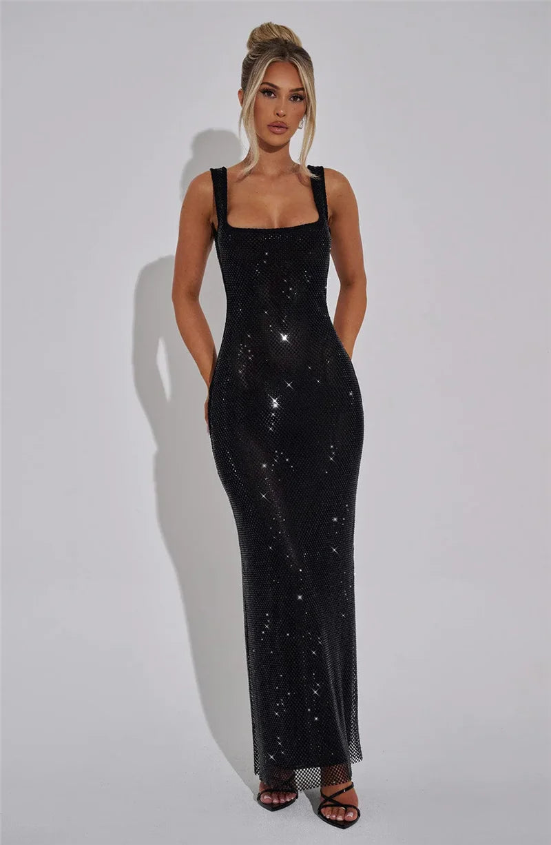 Woman wearing a black sequin dress against a plain background