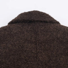 Close-up of a brown textured fabric with a collar on a white background