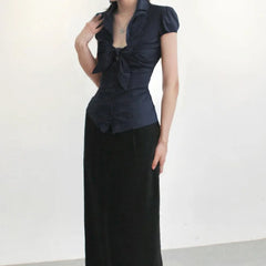 Woman wearing a blue top with a bow detail on a white background