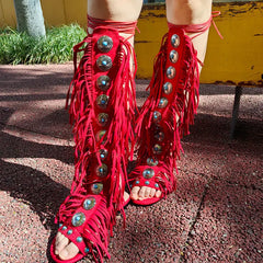 Full view of red fringed gladiator sandals styled on legs