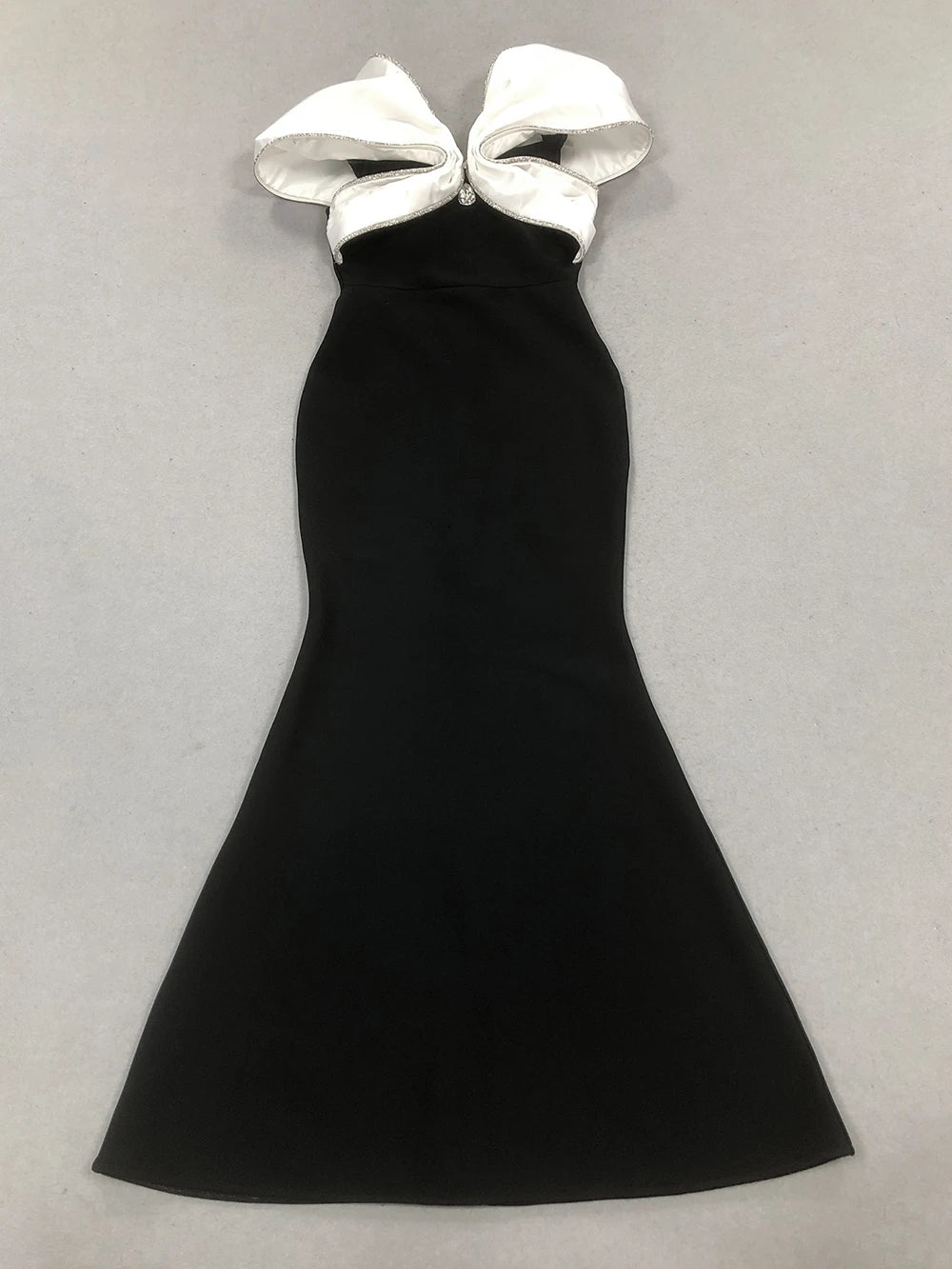 Black halter dress with large white bows on a light gray background
