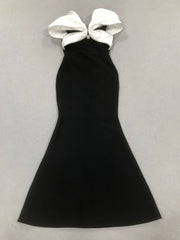 Black halter dress with large white bows on a light gray background