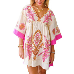 Model wearing a white mini dress with pink floral embroidery