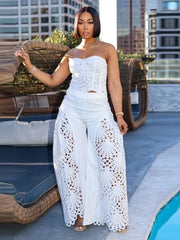 Woman in a white outfit standing by a pool with cityscape background