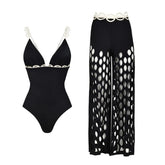 Black one-piece swimsuit with white scalloped trim and matching wide-leg cutout pants.