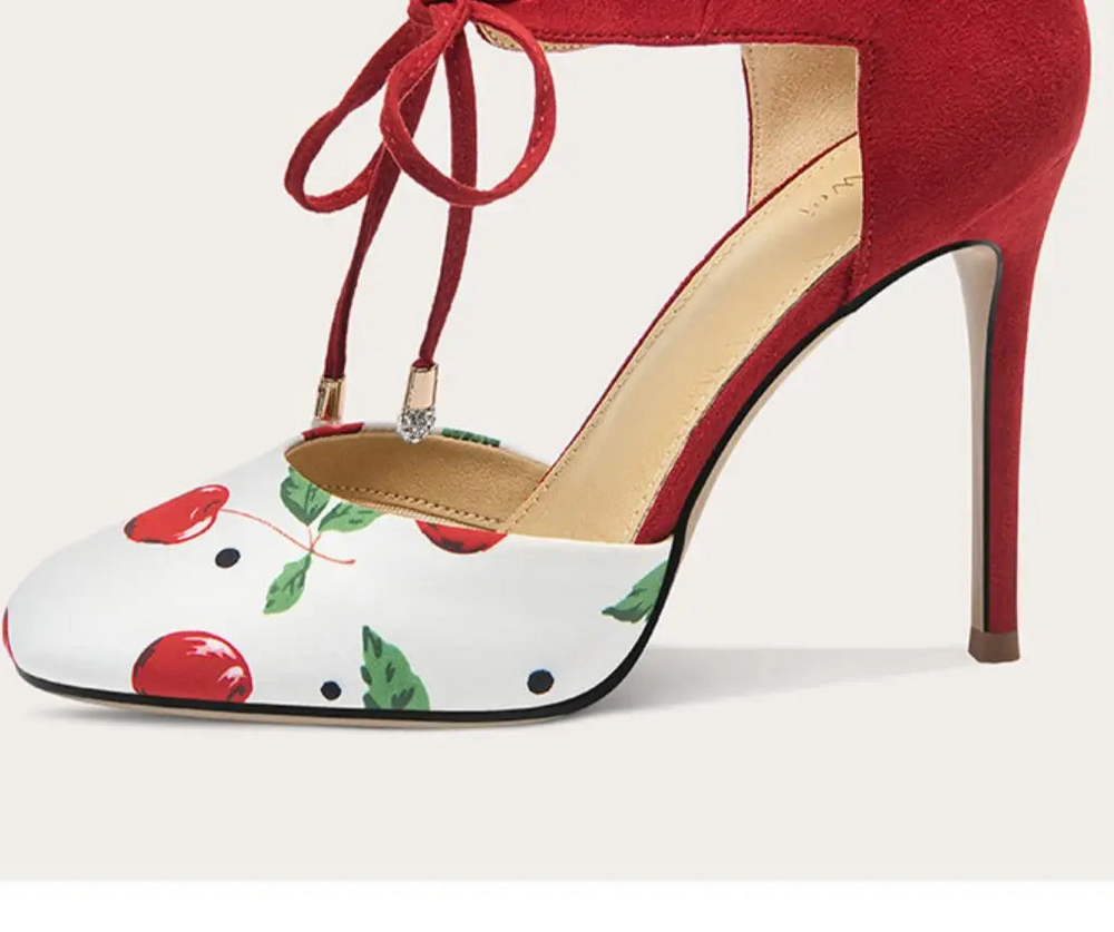 High-heeled shoe with cherry design on a white background
