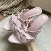 Pink pointed toe mules with a delicate bow detail