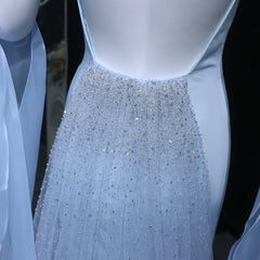 Close-up of a light blue evening gown with a beaded skirt on a black background