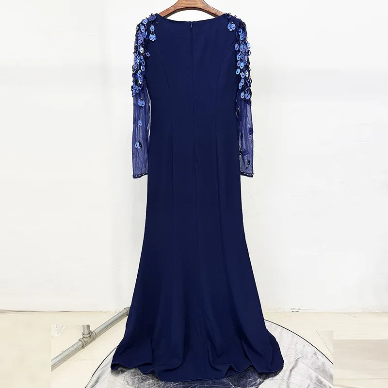 Navy blue evening gown with floral embellishments on a white background