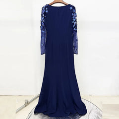 Navy blue evening gown with floral embellishments on a white background