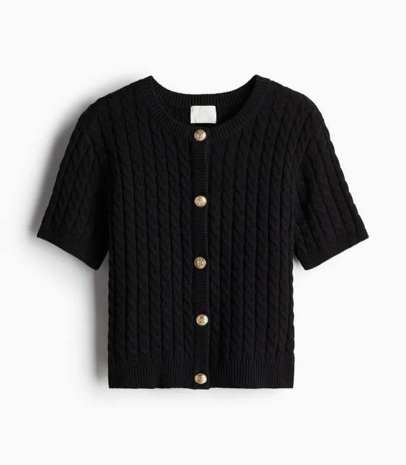 Black cable knit cardigan with gold buttons on a white background