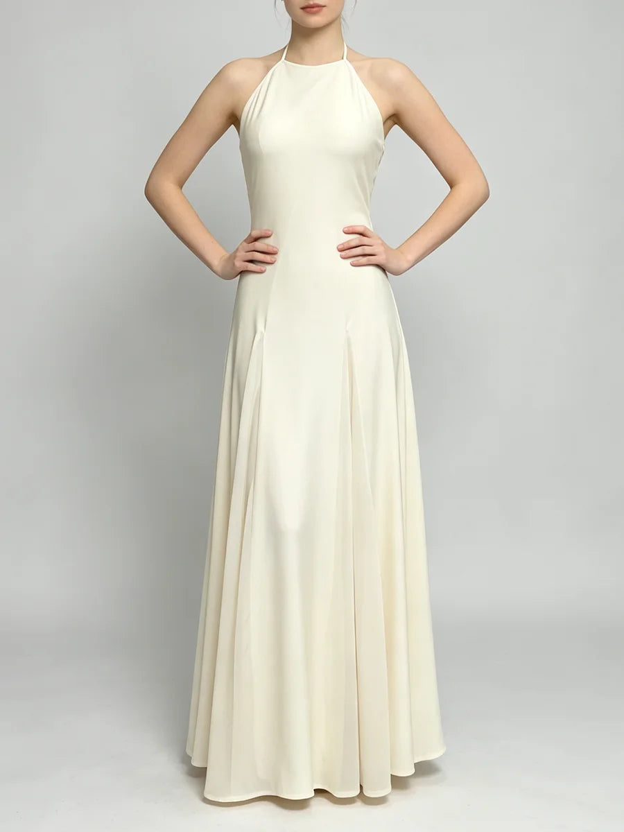 Front view of a sleeveless halter neck maxi dress with a pleated A-line skirt.