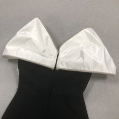 Black dress with white satin collar on a gray background