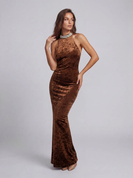 Woman wearing a brown velvet halter neck gown on a gray background