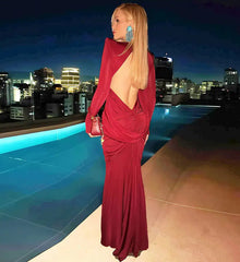 Woman in a red dress standing by a pool with city skyline
