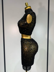 Black beaded two-piece outfit on a mannequin against a neutral background