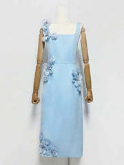 Light blue dress with floral embellishments on a mannequin against a white background